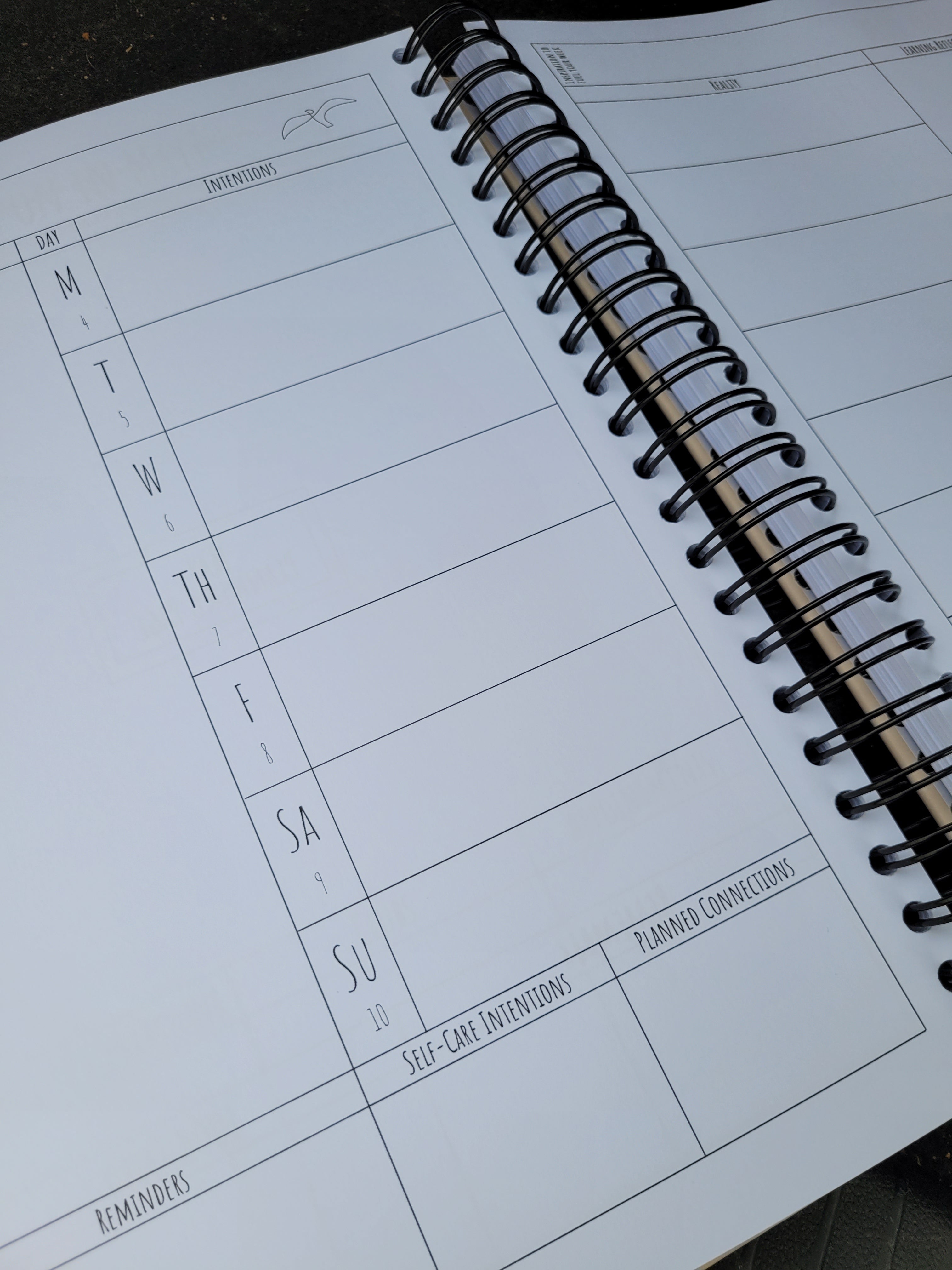 Spiral-bound planner with a weekly layout on a dark surface