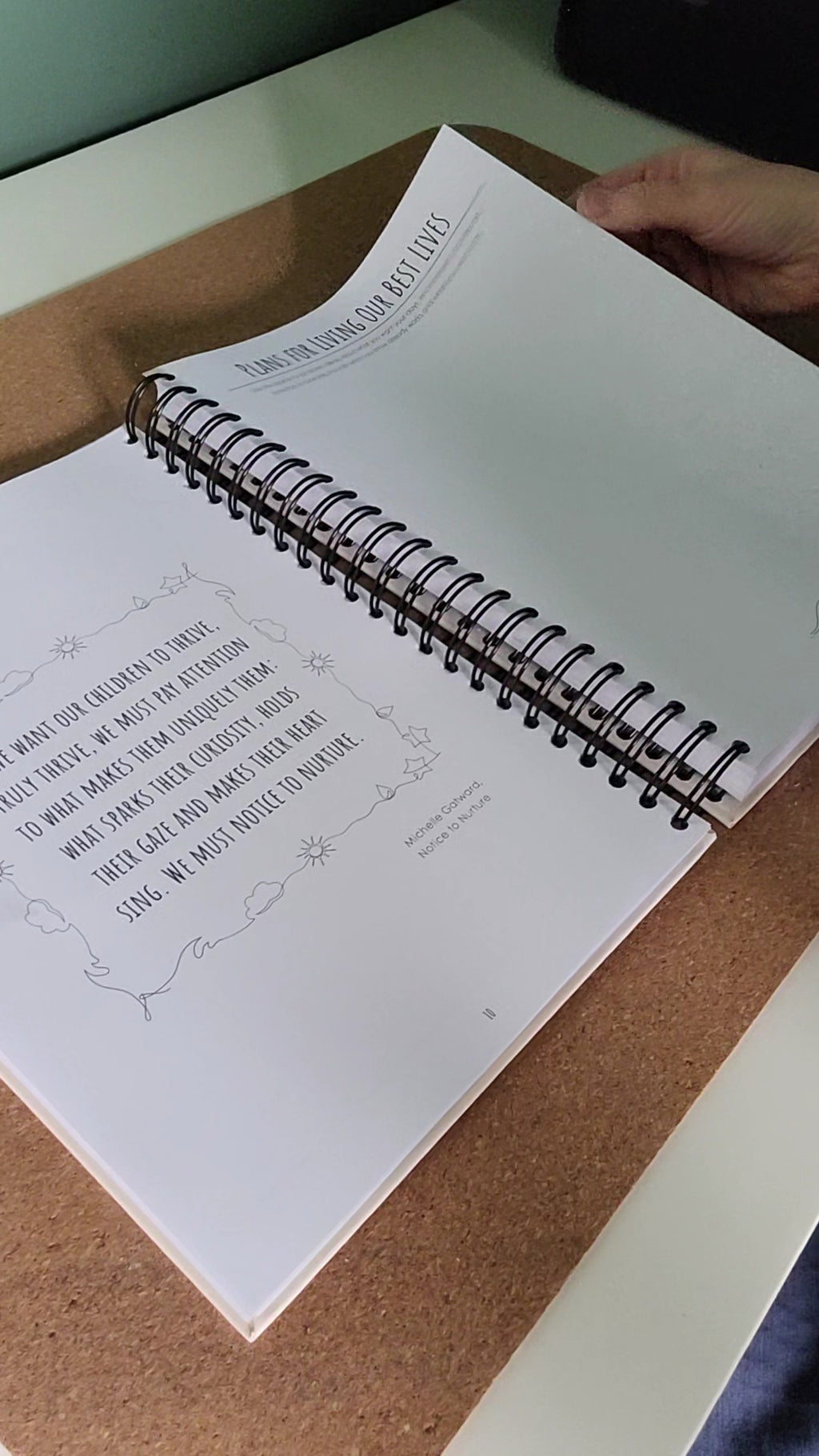 Spiral-bound notebook with text on a cork surface