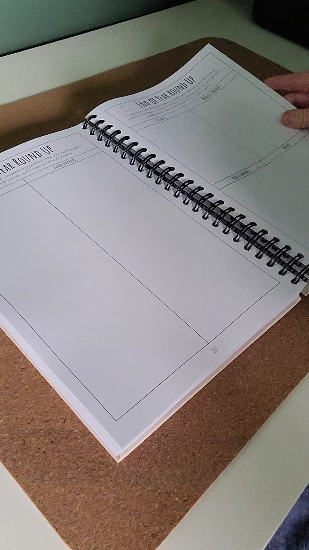 Open spiral-bound notebook on a cork surface