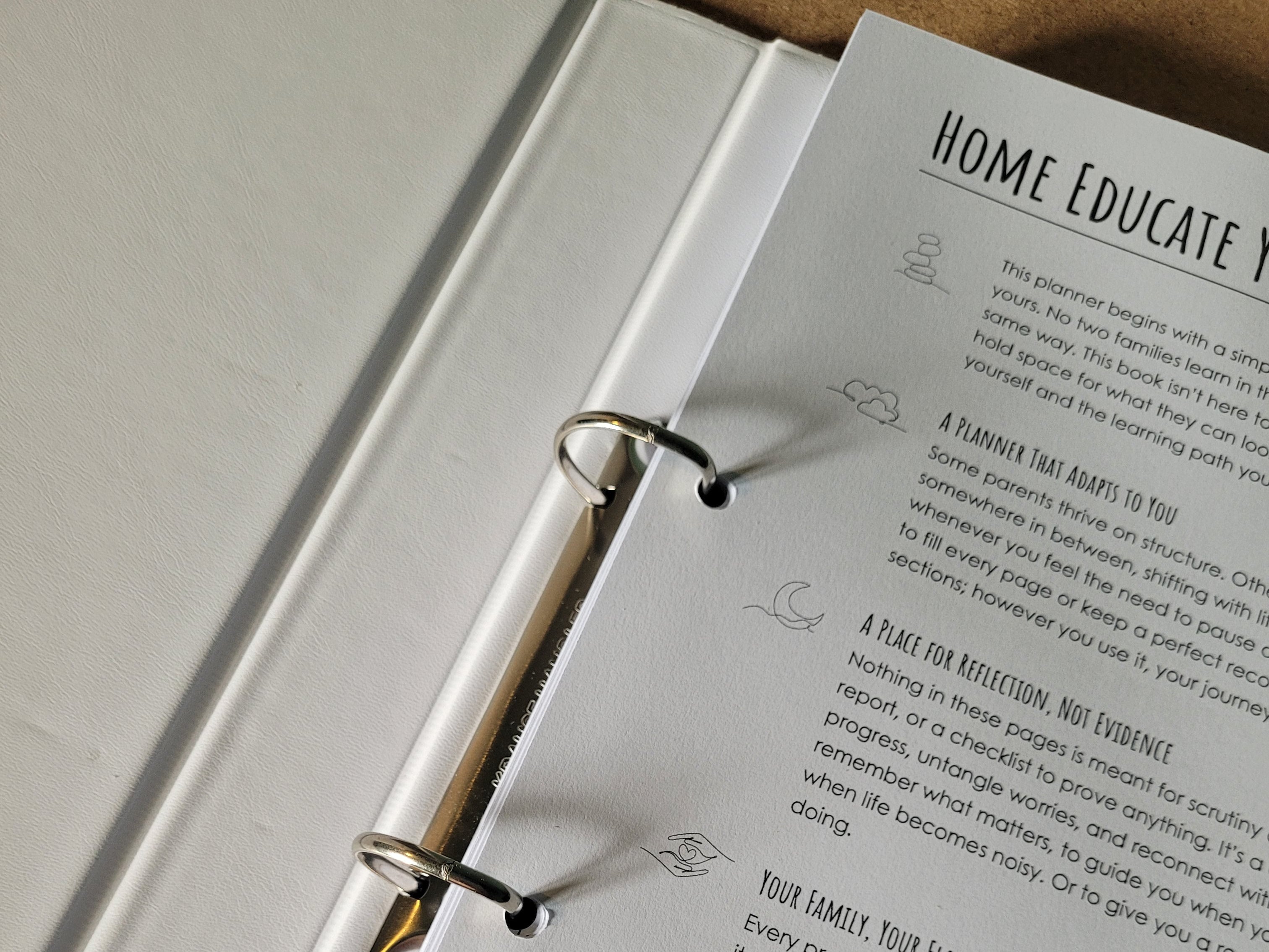 Open ring binder planner with text on a cork surface